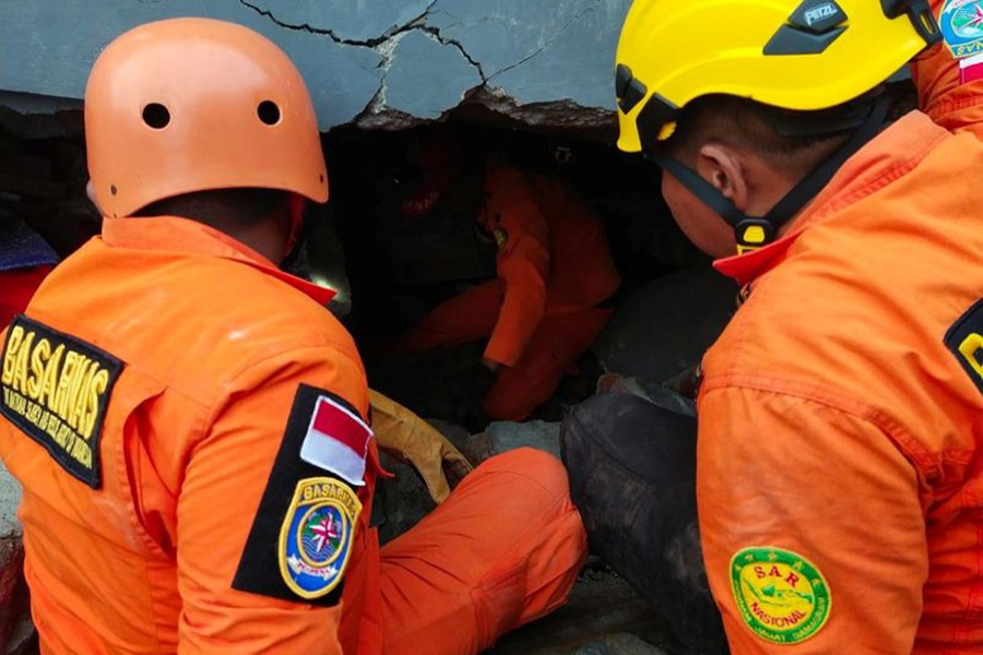 Members of a search and rescue agency team dig through rubble after an earthquake, in Mamuju, West Sulawesi Province, Indonesia January 15, 2021 — Basarnas Sulbar via REUTERS