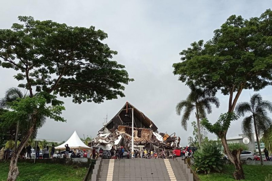 People look at the damaged governor of West Sulawesi province's office following an earthquake in Mamuju, West Sulawesi province, Indonesia, January 15, 2021 in this photo taken by Antara Foto –Antara Foto/Akbar Tado/via Reuters