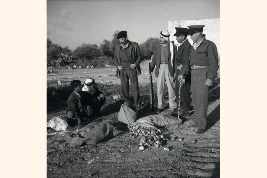 Israeli military policemen inspect a suspicious sack of onions found in possession of Arab citizens, in 1952