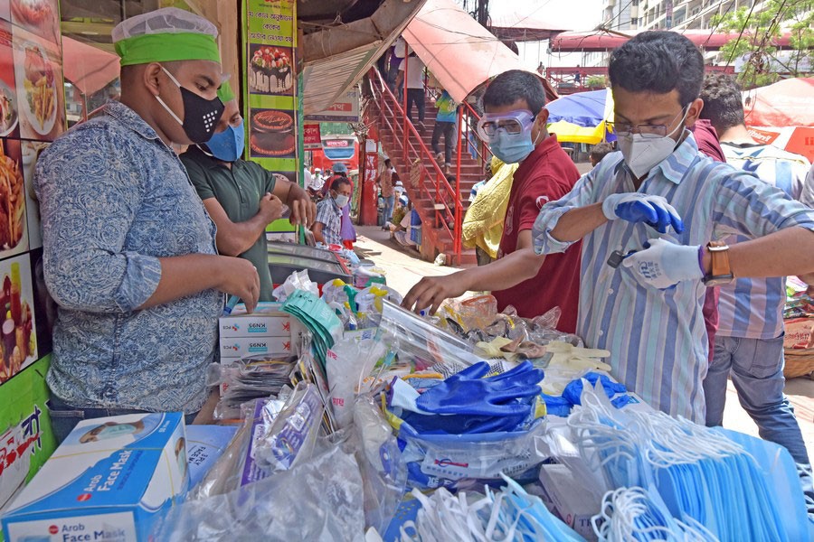 Street vending is an example of informal economy. People buy face masks and sanitary products from street vendors in Dhaka —Xinhua photo