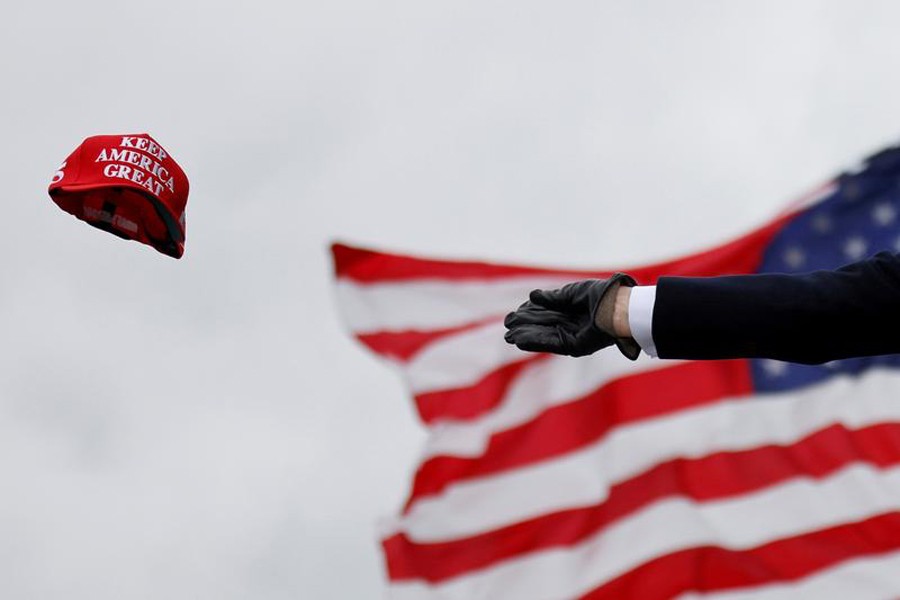 US President Donald Trump tosses out 'Keep America Great' caps as he arrives for a campaign rally at Oakland County International Airport in Waterford Township, Michigan, US on October 30, 2020 — Reuters/Files