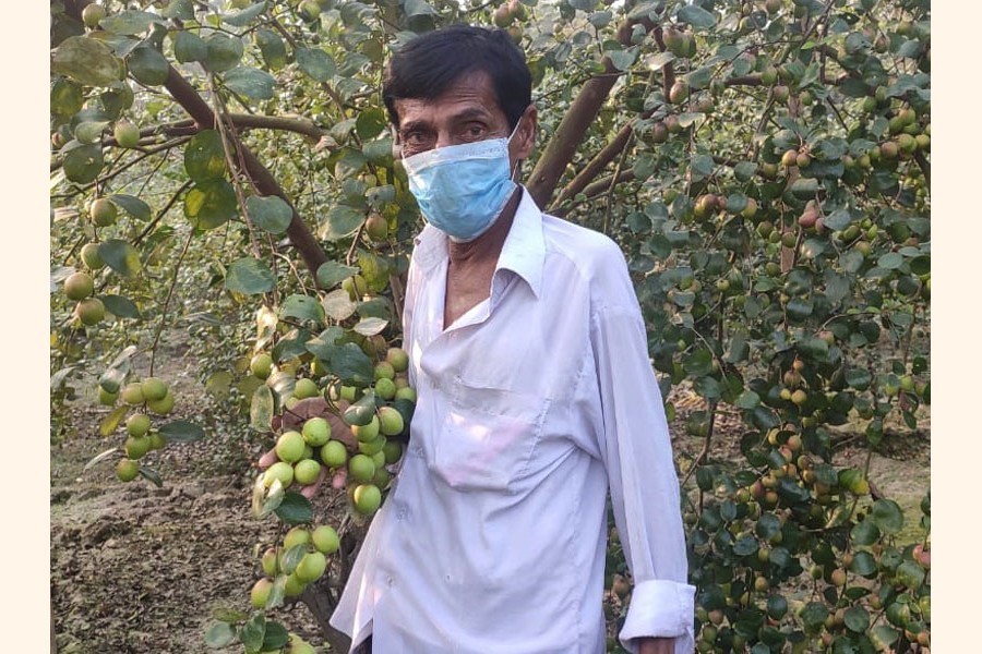 A hearing-impaired farmer, Hossain Sardar posing at his plum garden in Khulna’s Dumuria — FE Photo