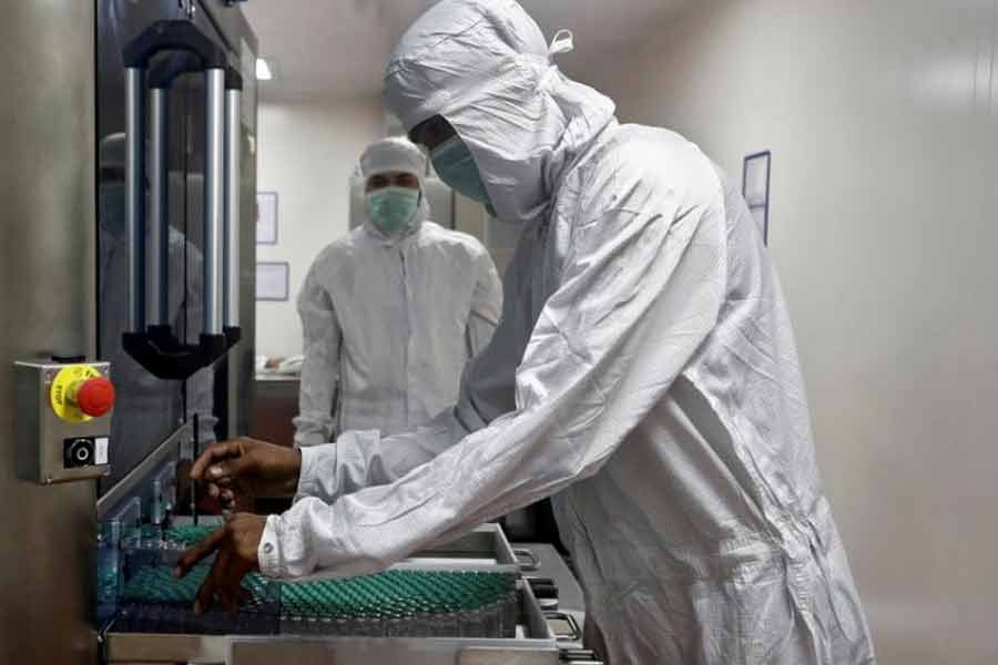 An employee removing vials of AstraZeneca's coronavirus disease (COVID-19) vaccine from a visual inspection machine inside a lab at Serum Institute of India in November last year –Reuters file photo