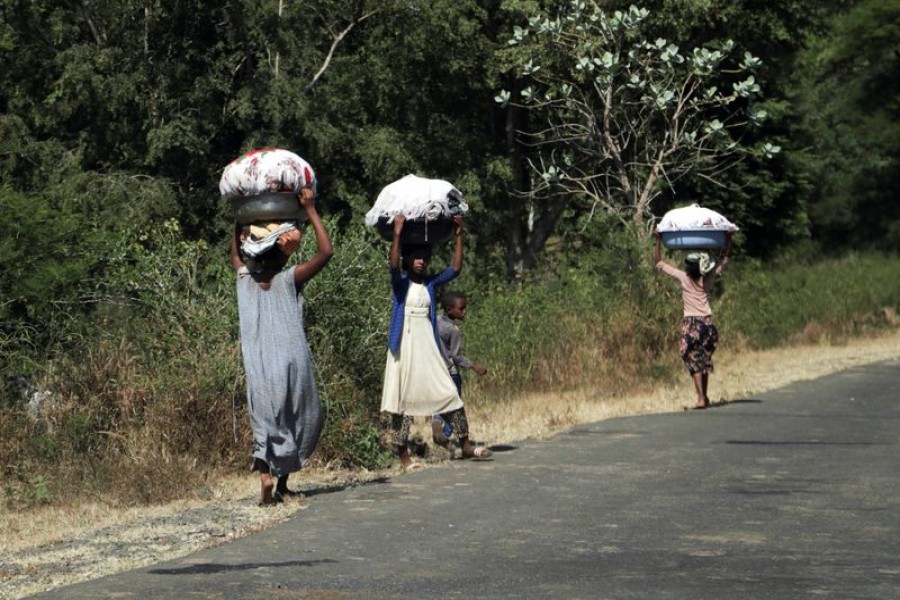 Girls carry laundry in Soroka town in Amhara region near a border with Tigray, Ethiopia. REUTERS