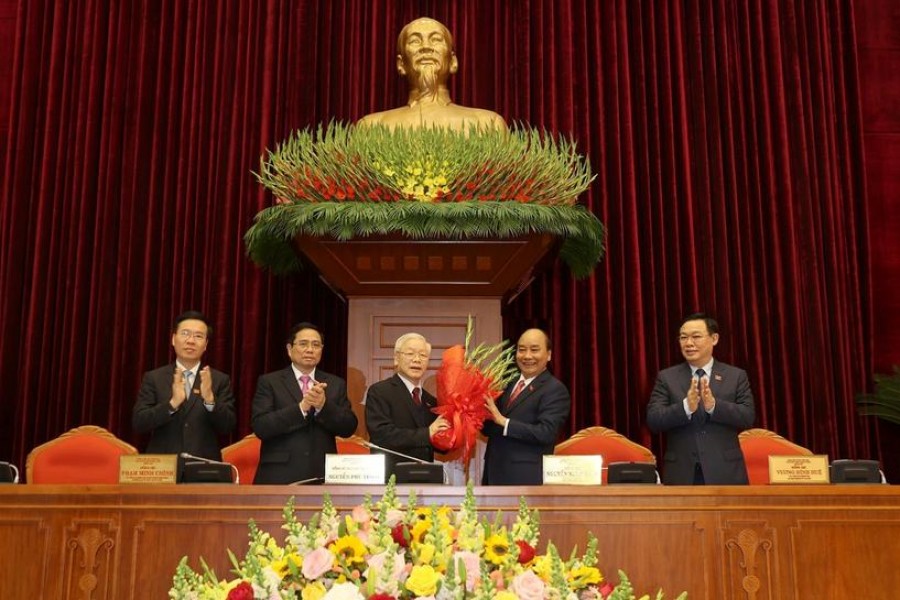 Vietnam's President and General Secretary of the Communist Party Nguyen Phu Trong (3rd L) receives flowers from Prime Minister Nguyen Xuan Phuc after he was re-elected as party chief for a 3rd term during the 13th national congress of the ruling communist party in Hanoi, Vietnam January 31, 2021. L-R are politburo members Vo Van Thuong, Pham Minh Chinh and Vuong Dinh Hue. VNA via REUTERS