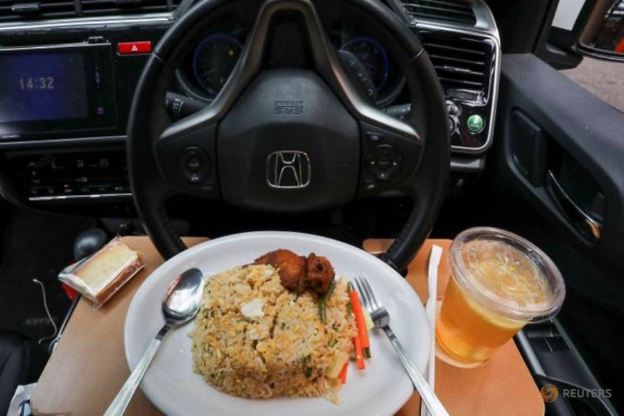 A dish for a drive-in dining service is served in a car in Cyberjaya, Malaysia during a lockdown due to the COVID-19 outbreak on Feb 4, 2021. (Photo: Reuters/Lim Huey Teng)
