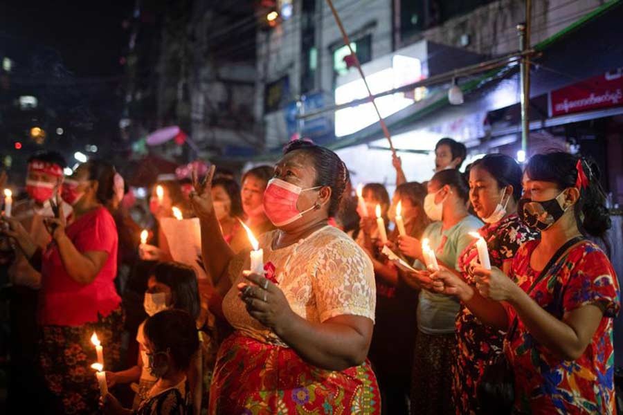 Women wearing red ribbons hold candles during a night protest against the military coup in Yangon, Myanmar, on Friday -Reuters photo