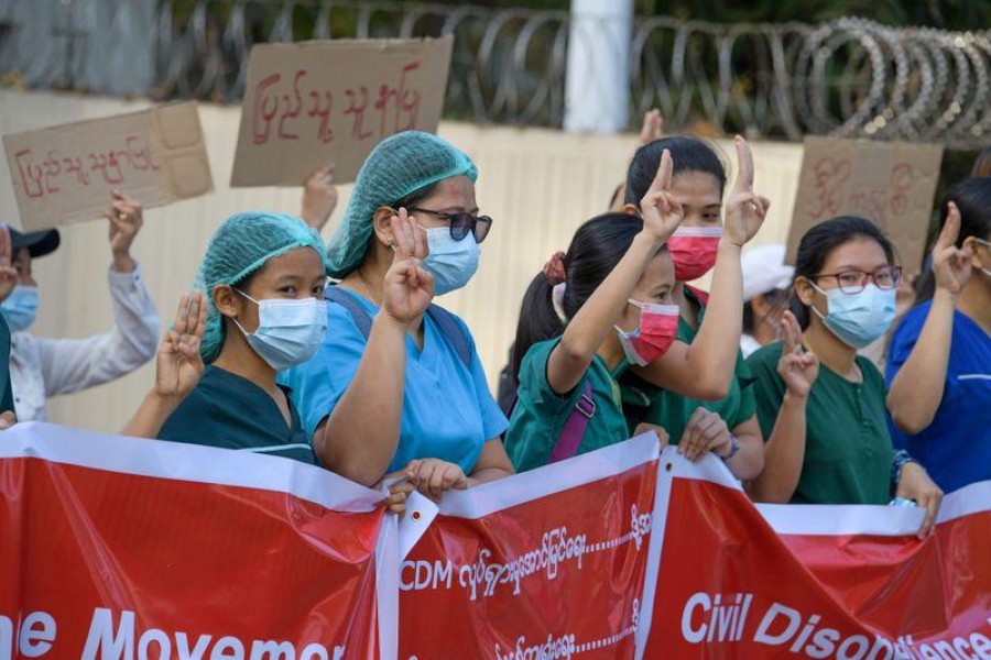 Nurses show the three-finger salute as they rally in a protest against the military coup and to demand the release of elected leader Aung San Suu Kyi, in Yangon, Myanmar, February 8, 2021. REUTERS/Stringer