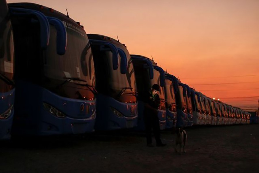 A security guard stands next to a line of buses that are used to transport Chinese tourists around Thailand as they are seen idle due to travel bans and border closures from the global coronavirus disease (Covid-19) outbreak in a parking lot near Suvarnabhumi airport in Bangkok, Thailand on February 5, 2021 — Reuters/Files