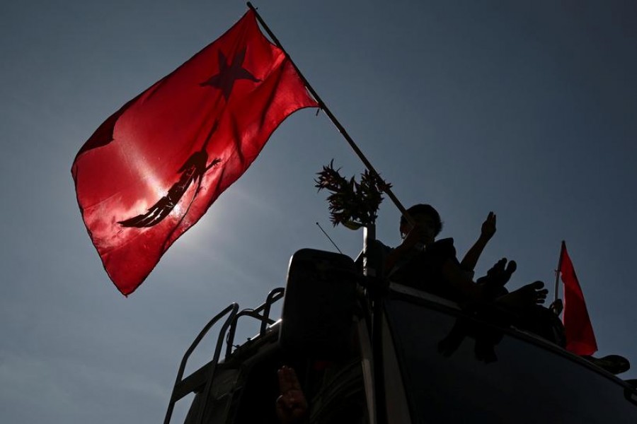 Demonstrators hold a flag and flash a three-finger salute as they protest against the military coup and demand for the release of elected leader Aung San Suu Kyi, in Yangon, Myanmar, February 12, 2021 — Reuters