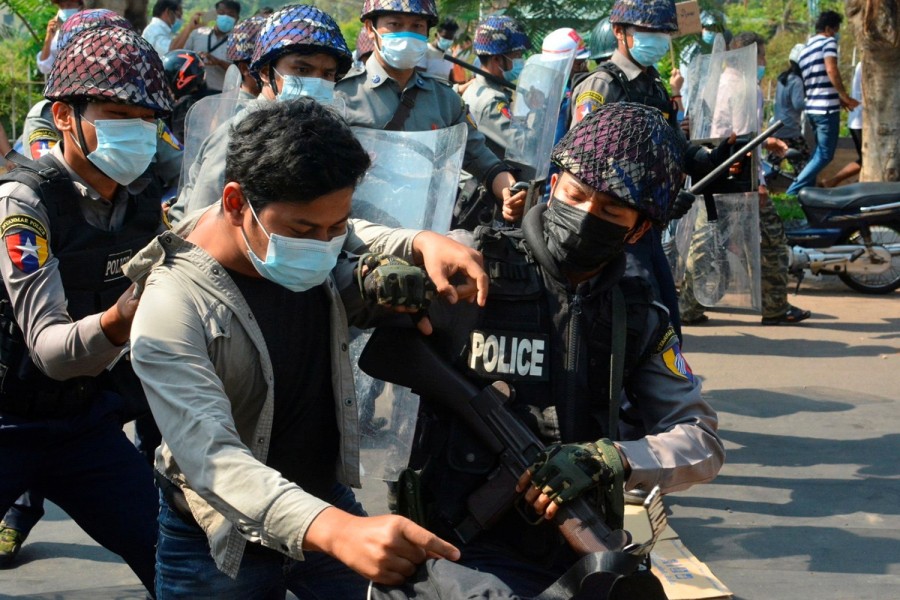 A demonstrator is detained by police officers during a protest against the military coup in Mawlamyine, Myanmar February 12, 2021. Than Lwin Times/Handout via REUTERS