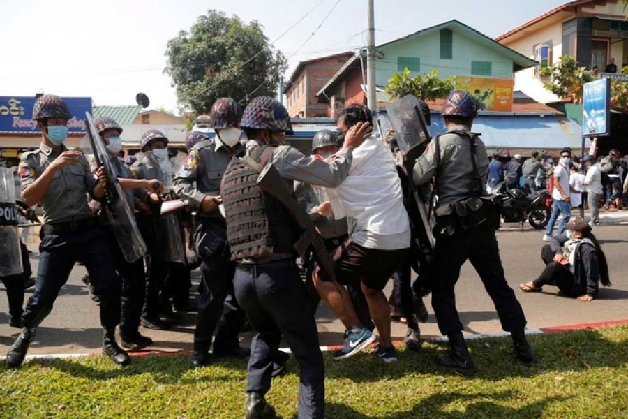 A demonstrator is detained by police officers during a protest against the military coup in Mawlamyine, Myanmar, February 12, 2021 — Reuters