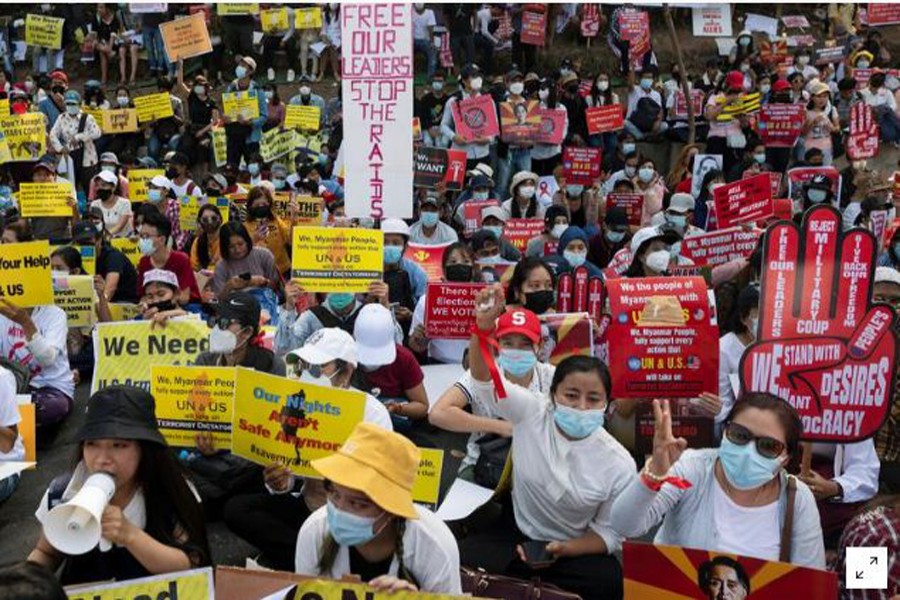 Demonstrators holding placards sit during a protest against the military coup outside the U.S. embassy in Yangon, Myanmar February 16, 2021. REUTERS/Stringer