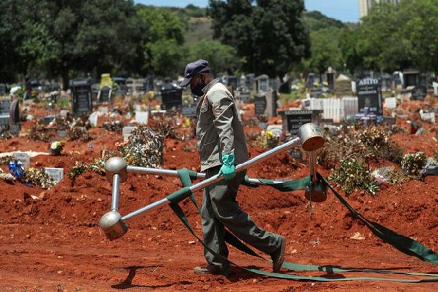 A funeral worker walks carrying a casket lowering device after a burial at the Westpark Cemetery, amid the coronavirus disease (Covid-19) outbreak, in Johannesburg, South Africa on December 24, 2020 — Reuters/Files