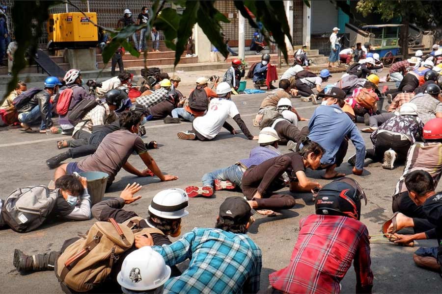 Protesters lie on the ground after police open fire to disperse an anti-coup protest in Mandalay of Myanmar on Wednesday -Reuters Photo