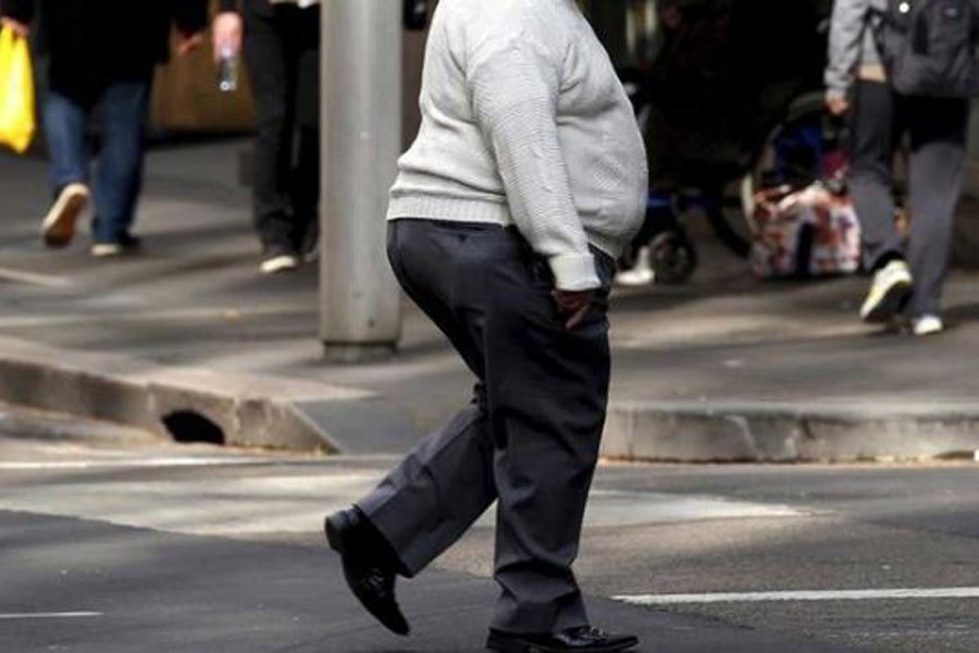 A man crosses a main road as pedestrians carrying food walk along the footpath in central Sydney, Australia. Reuters