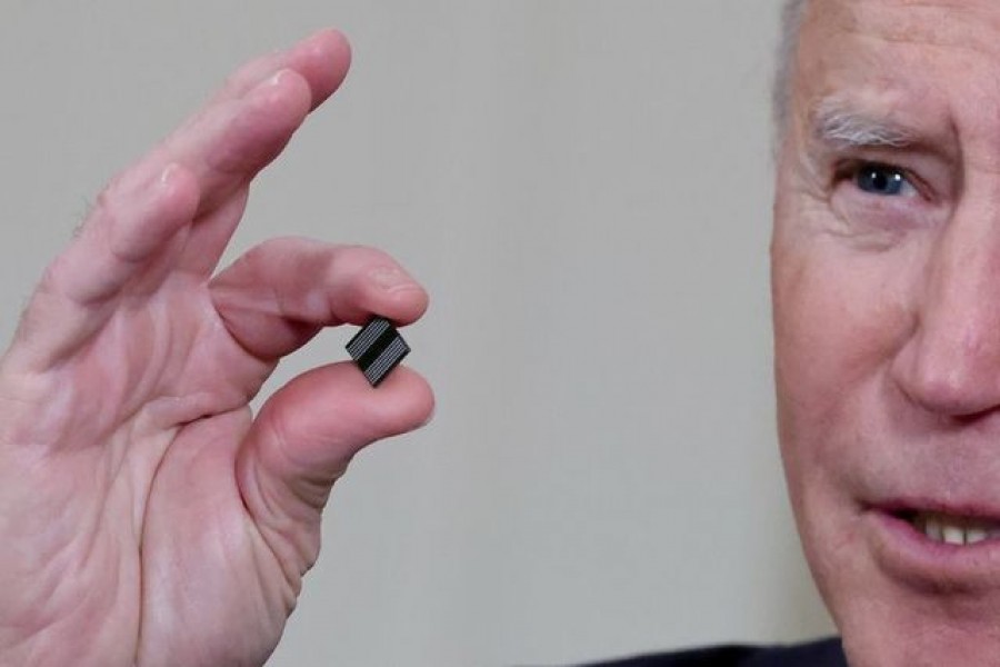 US President Joe Biden holds a semiconductor chip as he speaks prior to signing an executive order, aimed at addressing a global semiconductor chip shortage, in the State Dining Room at the White House in Washington, US, February 24, 2021. REUTERS/Jonathan Ernst