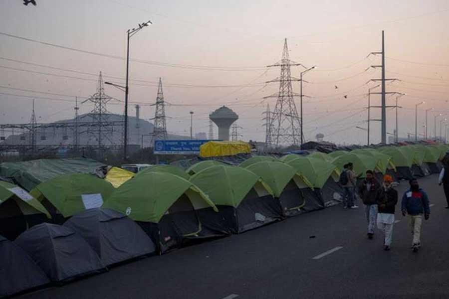 Farmers walk outside their tents at the site of a protest against new farm laws, at the Delhi-Uttar Pradesh border in Ghaziabad of India in January –Reuters file photo