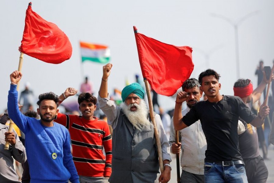 FILE PHOTO: Farmers shout slogans as they take part in a three-hour "chakka jam" or road blockade, as part of protests against farm laws on a highway on the outskirts of New Delhi, India, February 6, 2021. REUTERS/Adnan Abidi