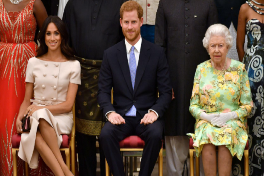 FILE PHOTO: Britain's Queen Elizabeth, Prince Harry and Meghan, the Duchess of Sussex pose for a picture with some of Queen's Young Leaders at a Buckingham Palace reception following the final Queen's Young Leaders Awards Ceremony, in London, Britain June 26, 2018. John Stillwell/Pool via Reuters/File Photo