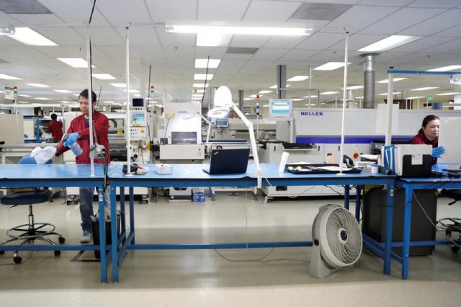 FILE PHOTO: Workers disinfect a production line while maintaining social distancing at the start of a shift at Green Circuits as the company, an essential business, adapts to operating during the outbreak of the fast-spreading coronavirus disease (COVID-19) in San Jose, California, US, April 2, 2020. REUTERS/Stephen Lam