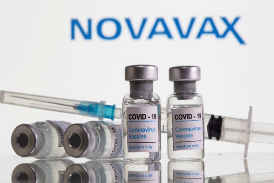 Vials labelled "COVID-19 Coronavirus Vaccine" and sryinge are seen in front of displayed Novavax logo in this illustration taken, February 9, 2021 — Reuters/Illustration