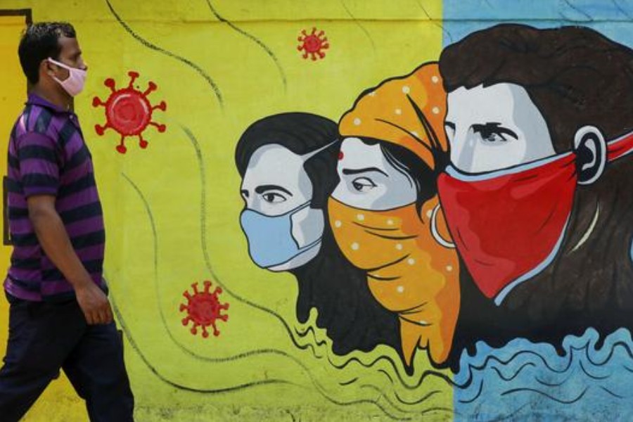 A man wearing a protective mask walks past a graffiti amidst the spread of the coronavirus disease (COVID-19) on a street in Navi Mumbai, India, March 8, 2021. REUTERS/Francis Mascarenhas