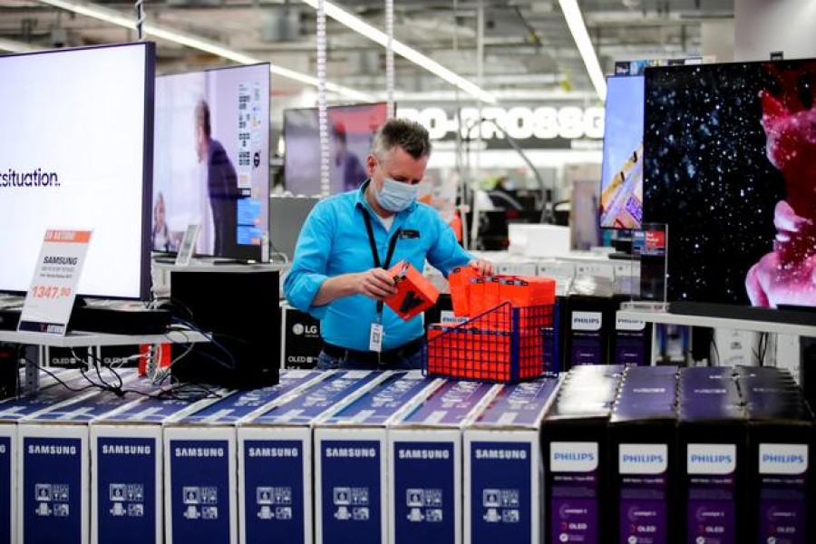 FILE PHOTO: An employee wearing a protective mask works at a Saturn electronic store as the coronavirus disease (COVID-19) lockdown measures are eased in Berlin, Germany, March 11, 2021. REUTERS/Hannibal Hanschke