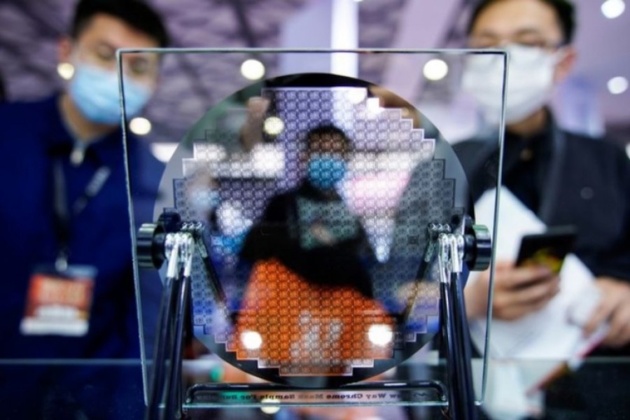 Visitors look at a display of a semiconductor device at Semicon China, a trade fair for semiconductor technology, in Shanghai, China March 17, 2021. REUTERS