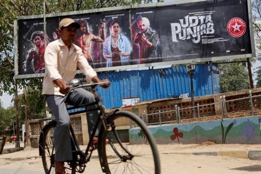 Representational image: A man rides his bicycle past a poster of the movie "Udta Punjab" in Mumbai, India, June 13, 2016 — Reuters/Files