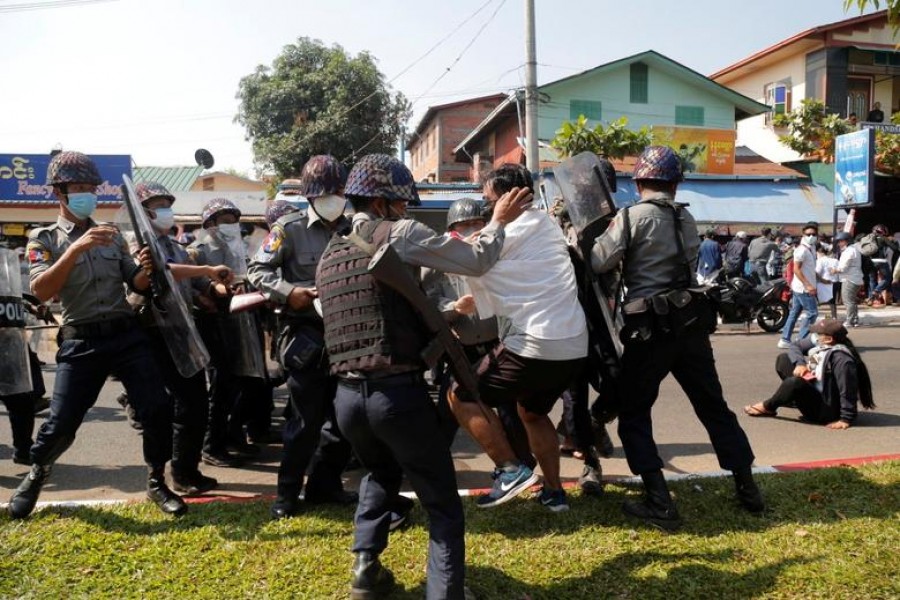 A demonstrator is detained by police officers during a protest against the military coup in Mawlamyine, Myanmar, February 12, 2021. Than Lwin Times/via REUTERS