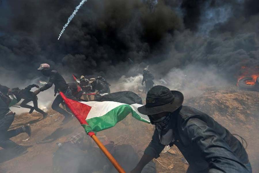 Palestinian demonstrators running for cover from Israeli fire and tear gas during a protest against US embassy move to Jerusalem in 2018 –Reuters file photo