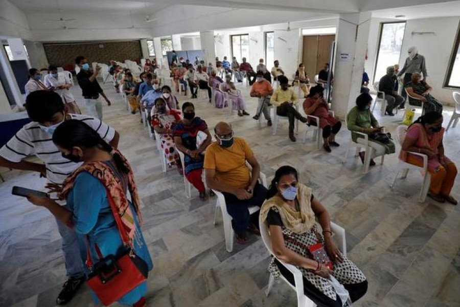 People sit in a waiting area to receive a dose of COVISHIELD, a coronavirus disease (COVID-19) vaccine manufactured by Serum Institute of India, at a vaccination centre in Ahmedabad, India, April 2, 2021. REUTERS/Amit Dave