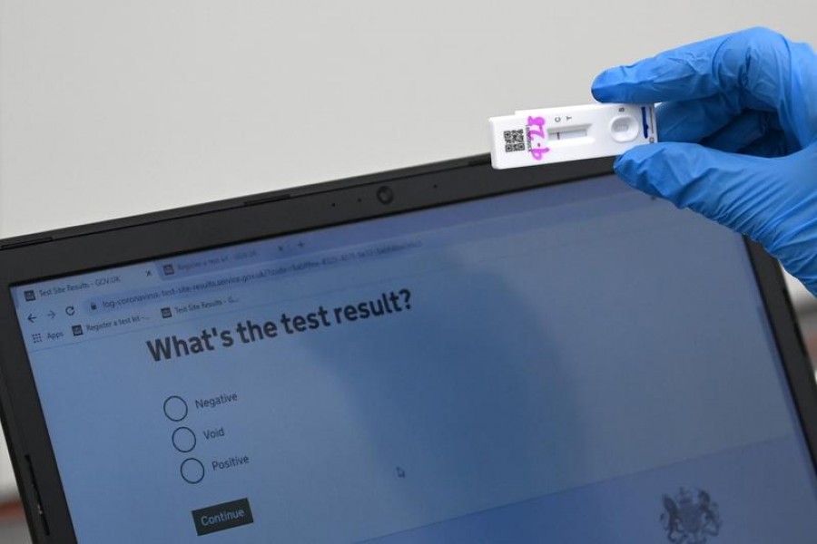 FILE PHOTO: Health workers and volunteers handle lateral flow test samples and record results as students take coronavirus disease (Covid-19) tests at Harris Academy Beckenham, ahead of full school reopening in England as part of lockdown restrictions being eased, in Beckenham, south east London, Britain, March 5, 2021. REUTERS/Toby Melville