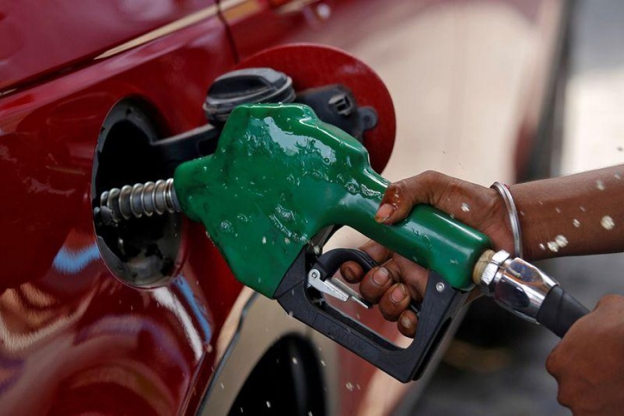 A worker holds a nozzle to pump petrol into a vehicle at a fuel station in Mumbai, India on May 21, 2018 — Reuters/Files