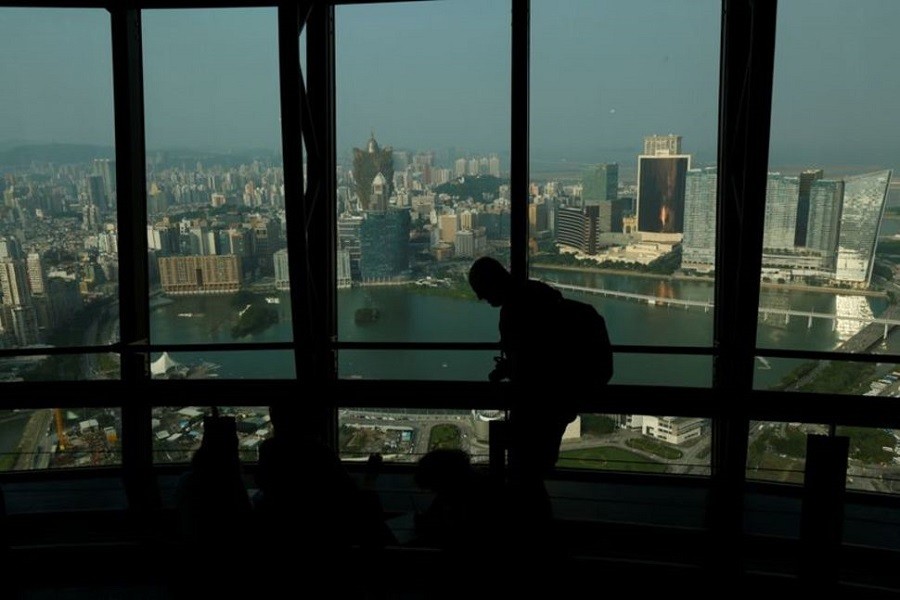 A visitor walks inside Macau Tower overlooking a general view of Macau peninsula, China, October 8, 2015 — Reuters/Files