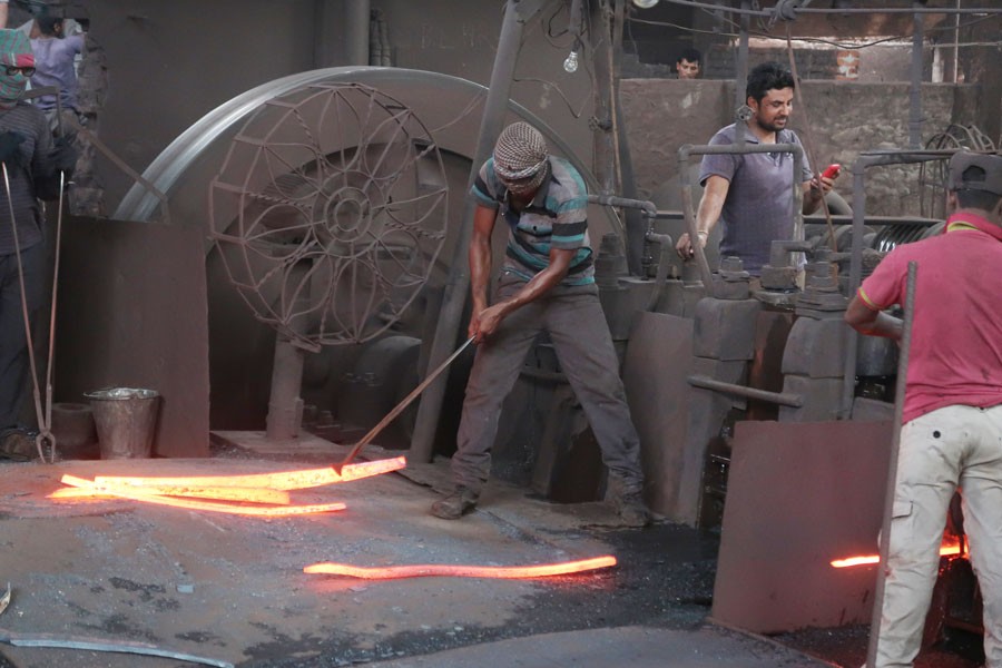 Workers at a re-rolling factory in Dhaka	—FE Photo