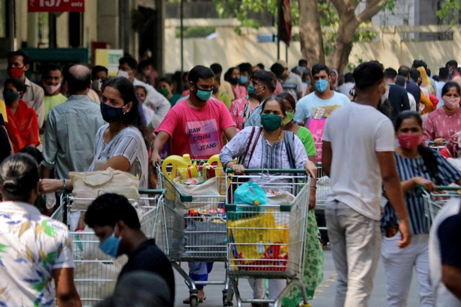 People push trolleys loaded with grocery items as others wait to enter a supermarket, amidst the spread of the coronavirus disease (Covid-19) in Mumbai, India on April 14, 2021 — Reuters photo