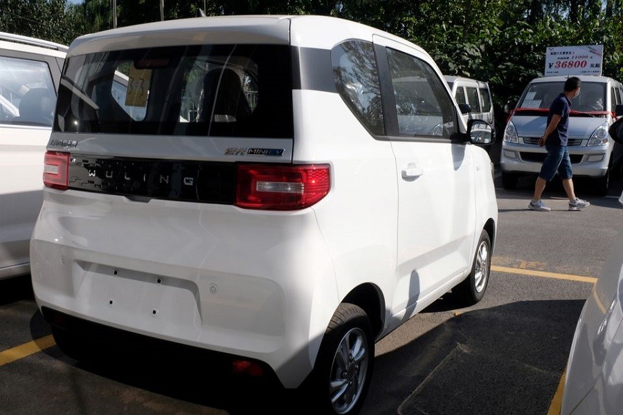 A man walks past a Wuling Hong Guang MINI EV (C) at a SAIC-GM-Wuling dealership in Beijing, China, September 20, 2020. REUTERS