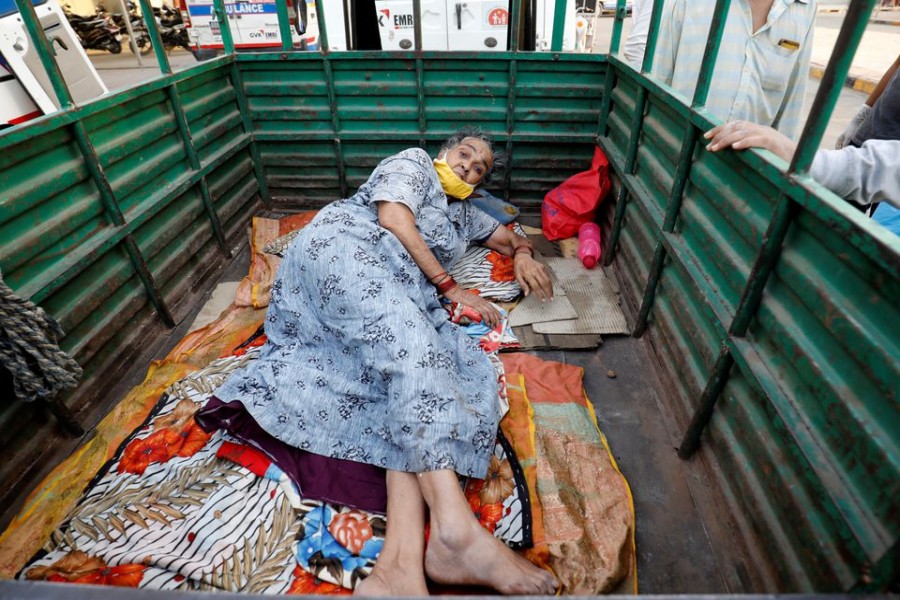 A woman lies in the back of a load carrier waiting to enter a COVID-19 hospital for treatment, amidst the spread of the coronavirus disease (COVID-19), in Ahmedabad, India, April 26, 2021. REUTERS/Amit Dave