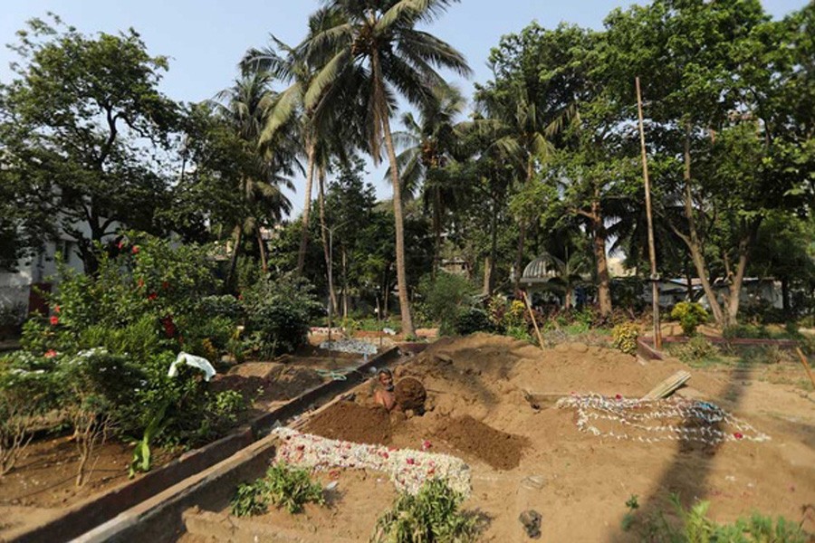 An assistant of Sayyed Munir Kamruddin, a gravedigger, prepares a grave for coronavirus disease (COVID-19) burials at a graveyard in Mumbai, India Apr 28, 2021. REUTERS