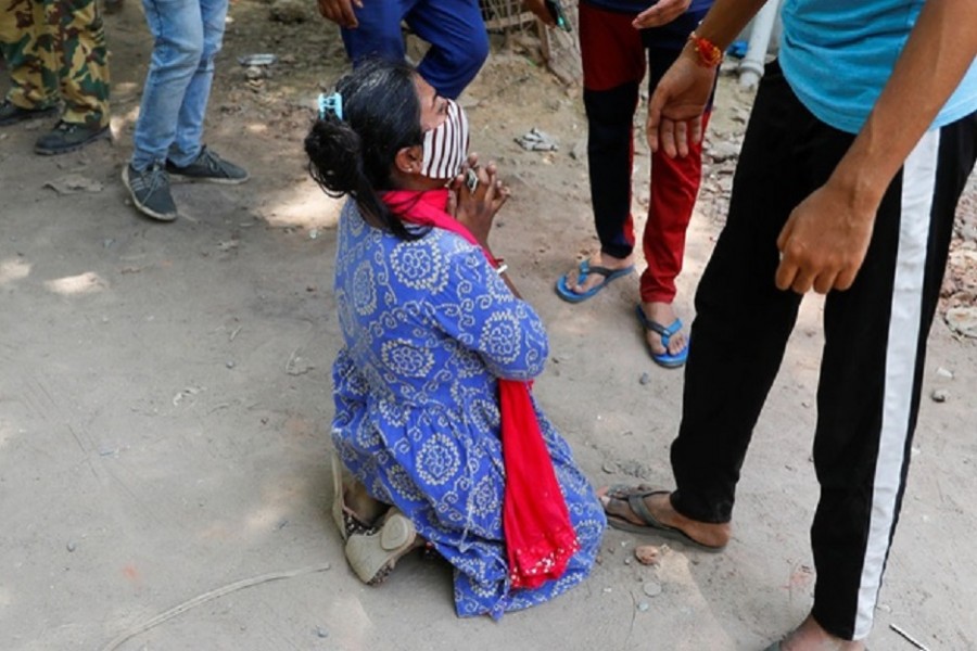 Shruti Saha, who had been waiting since Tuesday night for her turn to get an oxygen cylinder refilled for her mother, reacts after she was informed about her mother's death, outside a refilling workshop, in New Delhi, India, April 28, 2021. Reuters