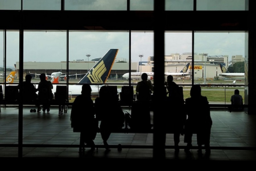 People look at a Singapore Airlines plane, amid the spread of the coronavirus disease (COVID-19), at a viewing gallery of the Changi Airport in Singapore October 12, 2020. Reuters