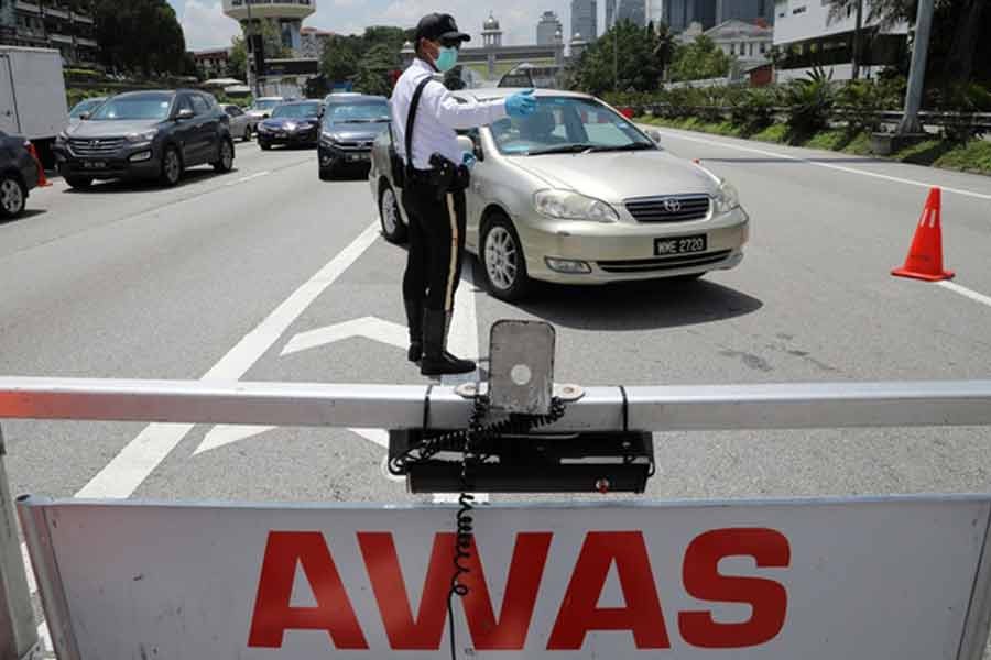 A police officer standing guard at a roadblock during lockdown ahead of the Eid al-Fitr celebrations in an effort to prevent a large-scale transmission of the coronavirus disease (COVID-19), in Petaling Jaya, Malaysia, on Monday -Reuters photo