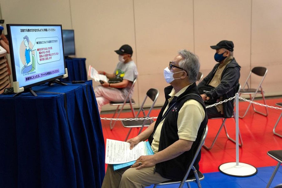 People wait to be processed after arriving to receive the Moderna coronavirus disease (Covid-19) vaccine at the newly-opened mass vaccination centre in Tokyo, Japan on May 24, 2021 — Pool via REUTERS