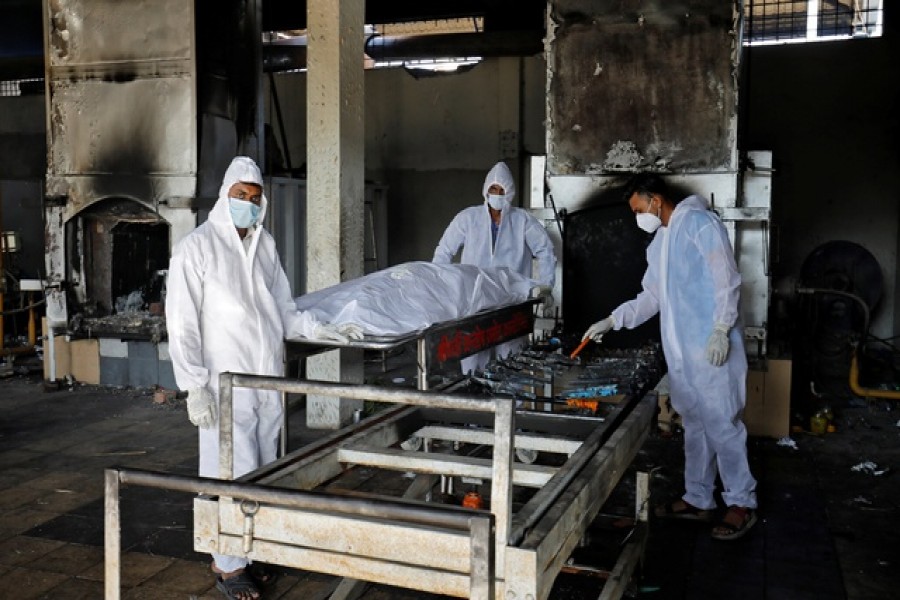 Volunteers from the Khan Trust prepare to cremate the body of a person who died from the coronavirus disease (COVID-19), at the Kurukshetra Crematorium in Surat, India, May 11, 2021. Picture taken May 11, 2021. REUTERS