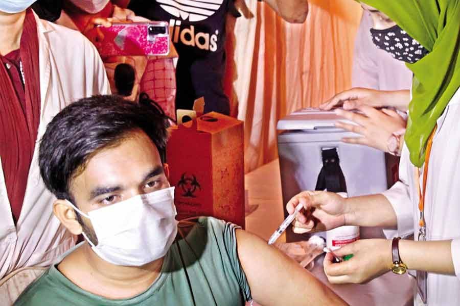 A health worker administers a dose of China's Sinopharm vaccine to a medical student at Dhaka Medical College Hospital on Tuesday — FE photo