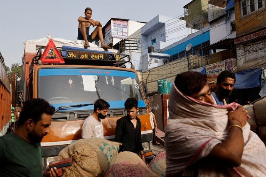 Workers load sacks of spices onto a truck at a wholesale market after authorities eased lockdown restrictions that were imposed to slow the spread of the coronavirus disease (COVID-19), in the old quarters of Delhi, India, June 8, 2021. Reuters