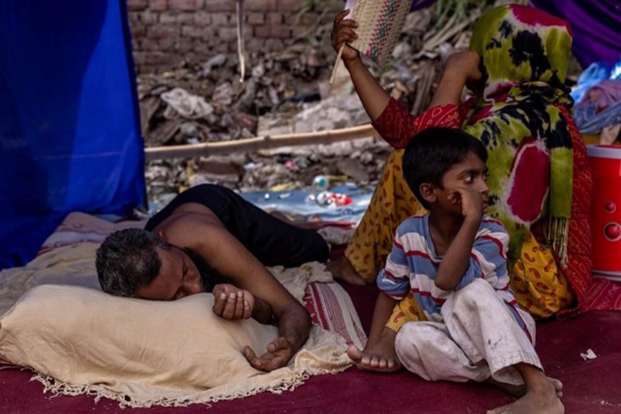 A Rohingya refugee family rests in a temporary shelter after a fire destroyed a Rohingya refugee camp on Saturday night, in New Delhi, India on June 14, 2021 — Reuters/Files