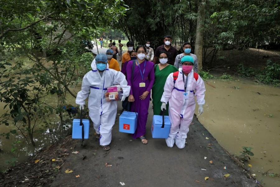 Healthcare workers carry COVISHIELD vaccine, a coronavirus disease (Covid-19) vaccine manufactured by Serum Institute of India, to inoculate villagers during a door-to-door vaccination and testing drive at Uttar Batora Island in Howrah district in West Bengal state, India on June 21, 2021 — Reuters photo